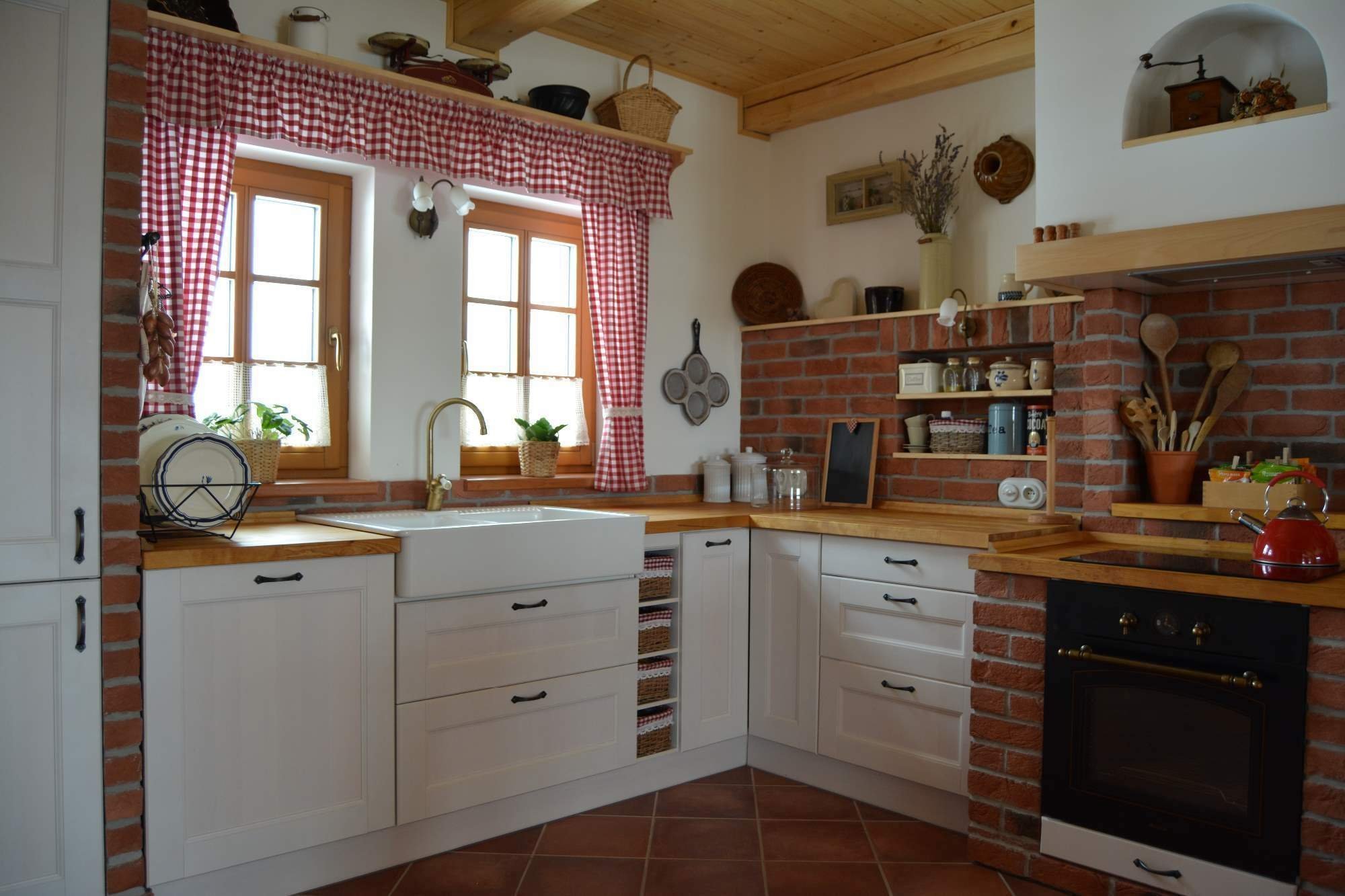 Prostorná rustikální kuchyně s&nbsp;moderními spotřebiči, doplněna památečnými kousky (formy, mlýnky, ošatky atd.) a cihlovým obkladem pro navození požadované…