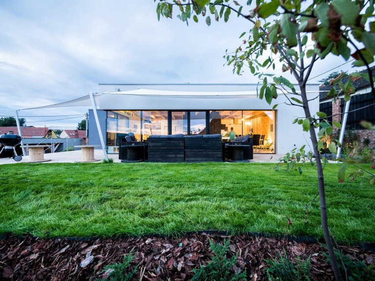 Strohá bílá hmota domu ZEN HOME je doplněna stínícími plachtami.
