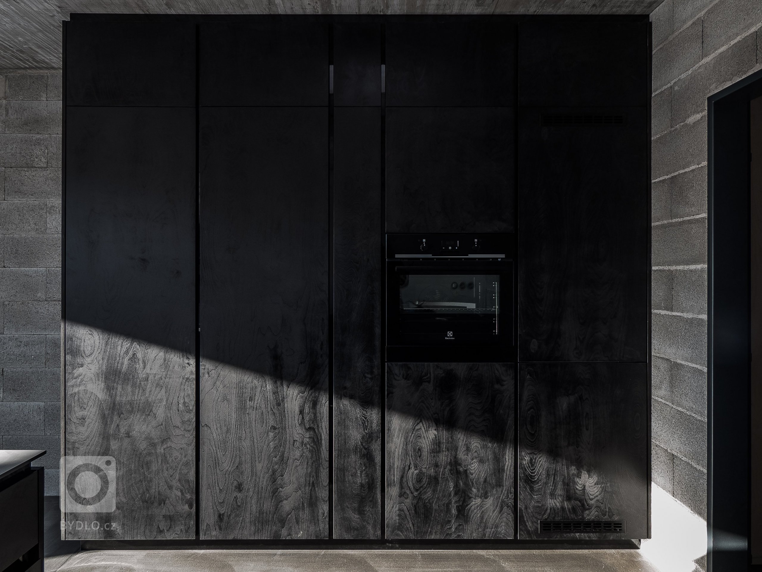 Kuchyň je z černě lakované překližky.