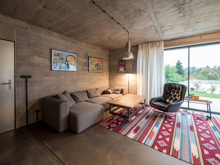 Obytný prostor ZEN HOME s velkým prosklením, které kotrastuje k masivním betonovým konstrukcím.
