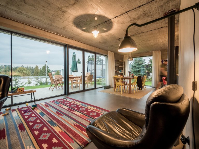 Obytný prostor ZEN HOME s velkým prosklením, které kotrastuje k masivním betonovým konstrukcím.
